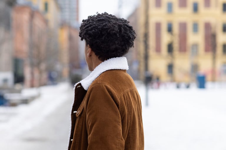 En mann som står midt i en snødekt gate.